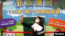 一名台北妇女在台湾新版护照发布广告前自拍留念。(2021年1月11日)