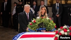 在国会大厦圆形大厅,当选总统唐纳德·特朗普和夫人梅拉妮亚·特朗普在前总统吉米·卡特的灵柩旁表达敬意。(2025年1月8日)