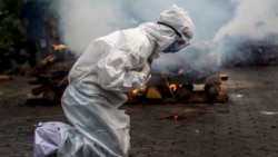 一名印度妇女在古瓦哈提市火葬场为患新冠死亡的亲人跪地祈祷。(2021年7月2日)