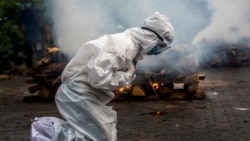 一名印度妇女在古瓦哈提市火葬场为患新冠死亡的亲人跪地祈祷。(2021年7月2日)