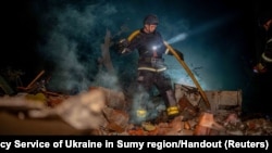 乌克兰一位消防员在俄空袭炸毁的一处民居建筑上。(2024年9月8日)