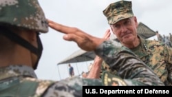 资料照:美国海军陆战队参谋长联席会议主席约瑟夫·邓福德将军参观中国解放军基地并向一位士兵敬礼。(2017年8月16日)