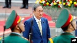 日本首相菅义伟在越南河内总统府检阅仪仗队。(2020年10月19日)