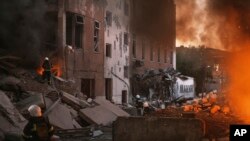 2022年6月18日,俄军就已经对尼古拉耶夫市进行过炮击。图为消防人员正试图扑灭由炮击造成的大火。-美联社照片