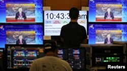 马来西亚吉隆坡的APEC视频会议中心的工作人员在观看中国领导人习近平发表视频讲话。(2020年11月19日)