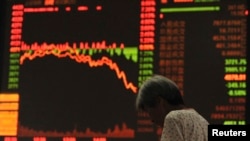 一位投资者站在安徽省阜阳市的股市电子板前(2015年7月27日)