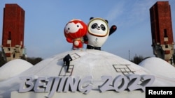 工人在北京冬奥会场馆树起冬奥会吉祥物冰墩墩和雪容融。(2022年1月11日)