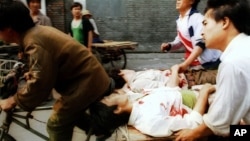 资料照:军队在北京对示威者开枪后,人们用三轮车把受伤的人送往附近医院。(1989年6月4日)