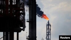 FILE - Excess natural gas is being flared, or burnt off, at a flare stack at the refinery in Tula.