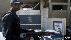 一名巴基斯坦警察持枪在卡拉奇一家工厂外站岗,据称两名中国公民在该工厂被枪杀。(2024年11月5日)