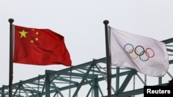 中国国旗和奥运旗帜在北京冬奥组委会外飘扬。(2021年3月30日)