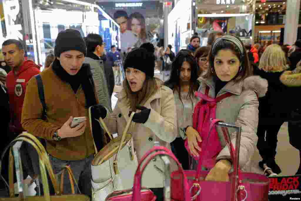 纽约曼哈顿的梅西百货先驱广场上黑色星期五的购物者,女士看着提包手袋 (2017年11月23日)。