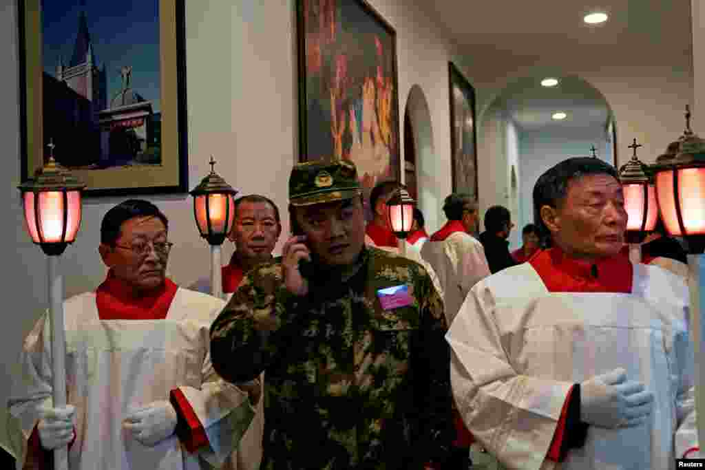 中国天主教徒2018年12月24日在上海的圣诞节前夕参加教堂弥撒,穿迷彩服者为保安人员。