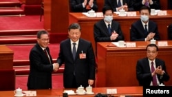 习近平(中)与李强握手,右一位卸任的总理李克强。