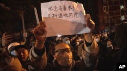 一名抗议者11月27日晚间在北京手举白纸抗议,上面写道:“纪念乌鲁木齐11.24遇难同胞”。自11月25日以来,中国多个城市爆发街头抗议,表达对政府“清零”政策的不满,还有抗议民众高喊要求“习近平下台”。(2022年11月27日)