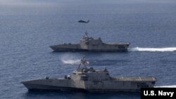 美军“蒙哥马利”号(USS Montgomery)(上)和“吉福兹”号(USS Gabrielle Giffords)濒海战斗舰2020年1月20日在一架海鹰直升机的掩护下在南中国海执行任务。