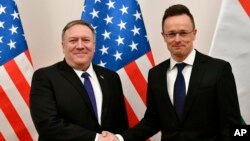 Hungarian Minister of Foreign Affairs and Trade Peter Szijjarto, right, shakes hands with US Secretary of State Mike Pompeo in the ministry in Budapest, Hungary, Feb. 11, 2019.