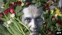 德国民众在一座前俄罗斯领事馆前在纳瓦尔尼肖像周围敬献鲜花。(法新社2024年2月19日)