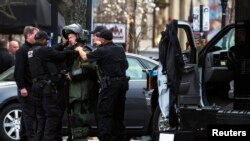 4月19日在波士顿,一名执法部门的技术人员穿上保护服,准备去引爆一个怀疑是炸弹的装置。