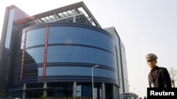 资料照:中芯国际在上海开业时一名保安站在楼前。(2001年11月22日)