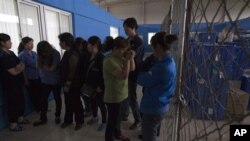 2013年6月25日,工人们聚集美国佛罗里达州专用医疗用品公司设在北京怀柔区桥梓镇分厂内。公司共同业主奇普.斯塔恩斯被工人困在厂内。