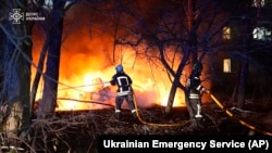 在这张由乌克兰紧急服务部门提供的照片中,2024年11月17日,乌克兰苏梅的一栋多层公寓楼遭到俄罗斯火箭弹袭击后,消防员正在扑灭大火。