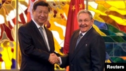 资料照 - 2014年7月22日,时任古巴总统劳尔·卡斯特罗(Raul Castro)(右)同中国国家主席习近平在古巴首都哈瓦那的革命宫会晤前握手。