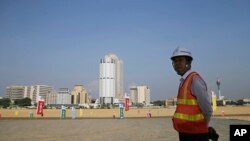 资料照片:一名中国建筑工人站在一带一路工程项目斯里兰卡科伦坡港口城工地上。(2018年1月2日)