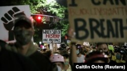 美国俄勒冈州波特兰市的抗议者手持标语,抗议非洲裔美国女子布雷娜·泰勒(Breonna Taylor)死亡事件。7月20日资料照。