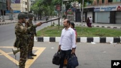 公职配额制度最近引起孟加拉国全国示威,政府已宣布延长宵禁。在首都达卡,一名军人要求一对夫妇返回家中。(2024年7月20日)