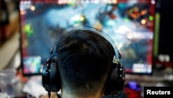 资料照:一名男子在北京的一家网吧玩电游。(2021年8月31日)