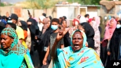 A pro-democracy protester flashes the victory sign as thousands take to the streets to condemn a takeover by military officials, in Khartoum, Sudan, Oct. 25, 2021.