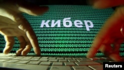 资料照:在电脑键盘上的两只手与屏幕上显示的网络代码 (路透社)