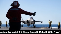 2025年7月14日,在“护身军刀25”演习期间,一架美国海军陆战队的F-35B闪电II飞机准备从两栖攻击舰“美国号”的飞行甲板上起飞,同时在珊瑚海进行飞行作业。