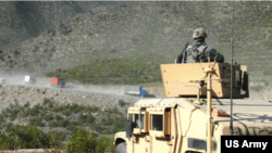 图为美军作战后勤巡逻队在阿富汗公路旁进行巡逻,保卫公路的安全。