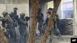 视频截图显示,2022年1月6日,在南部城市高雄进行城市巷战演练的台湾士兵准备进入一栋建筑物。