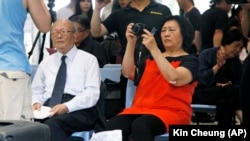 高瑜(右侧手持相机者)参加香港刘霞艺术展 (2012年6月资料照片)