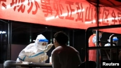 一名医护人员在给一名郑州市民做新冠病毒核酸检测。(2021年8月2日)