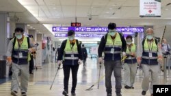 戴着口罩的工作人员在台北桃园机场喷洒消毒药水防范新冠病毒。(2020年1月22日)