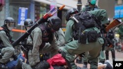 资料照:2020年5月24日,在香港铜锣湾举行的反对国安法的示威活动中,防暴警察拘留了一名抗议者。(美联社)