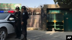 2017年11月2日,在新疆库尔勒市,警察站在一个被认为用于再教育的中心附近。