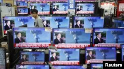 首尔的一名店员观看电视屏幕上有关朝鲜核试验的消息。(2016年1月6日)