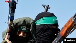 哈马斯武装战士在加沙中部参加纪念 2014 年与以色列战争周年的阅兵式。(路透社:2023年7月19日)