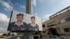 Two posters with pictures of Jordanian pilot, Lt. Muath al-Kaseasbeh, who is held by Islamic State group militants, and Arabic that reads "we are all Muath," hang on a street pole, in front of the captured pilot's tribal gathering place, in Amman, Jordan,