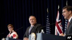 在美国国务院举行的记者会上,澳大利亚外长佩恩与美国国务卿蓬佩奥听着美国国防部长埃斯珀讲话。(2020年7月28日)