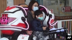 游客在台湾台北市台北儿童游乐园戴上口罩,以防止新的冠状病毒传播。(2020年4月11日)