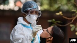 အိန္ဒိယတင် ကိုဗစ်ကပ်ရောဂါရှိမရှိစစ်ဆေးနေစဉ် (ယခင်မှတ်တမ်းဓါတ်ပုံ) (Photo by Money SHARMA / AFP)