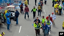 2013年4月15日,波士顿马拉松赛终点附近发生两起爆炸后,医疗救护人员紧急抢救伤者。