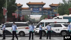 中国警察在被关闭的北京新发地农产品批发市场的入口处站岗。(2020年6月13日)