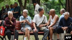 中国安徽省阜阳市的老人坐在一个公园的长椅上。(2024年9月13日)